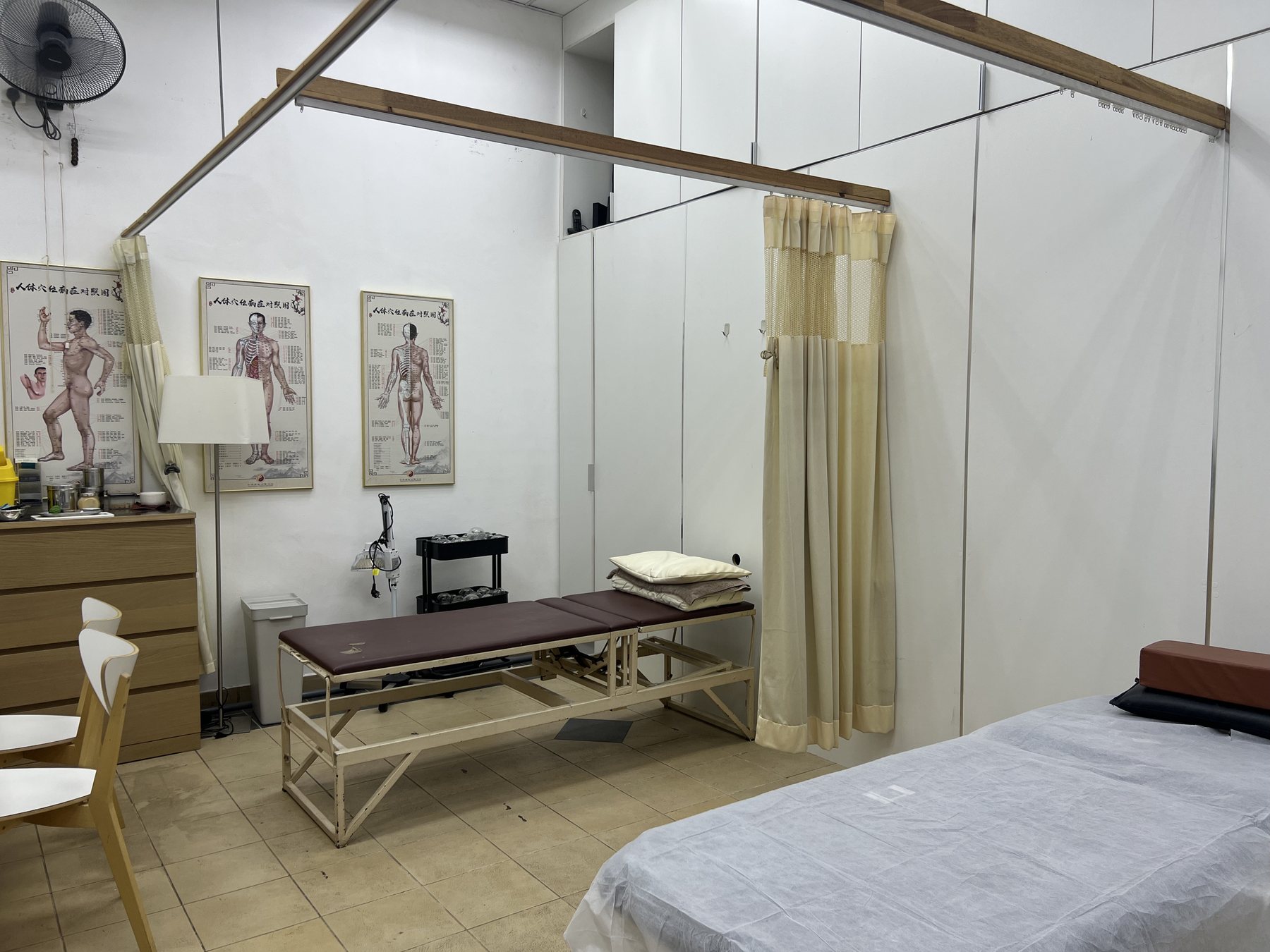 Treatment room with acupuncture charts at Kedai Ubat Xin An